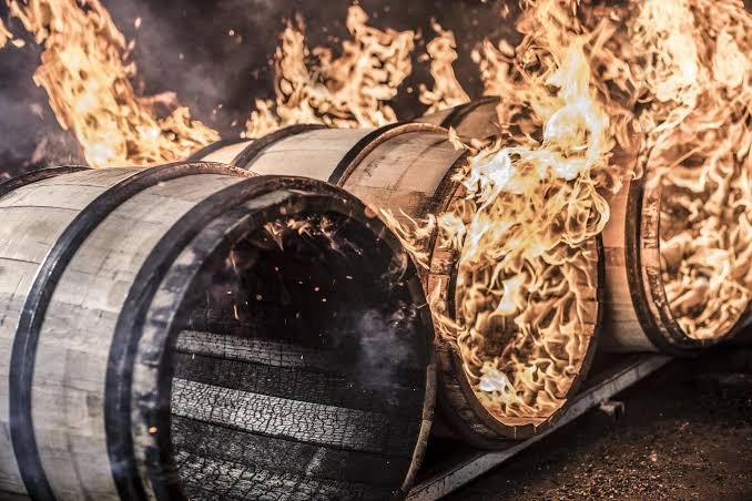 Oak casks being charred over open flame